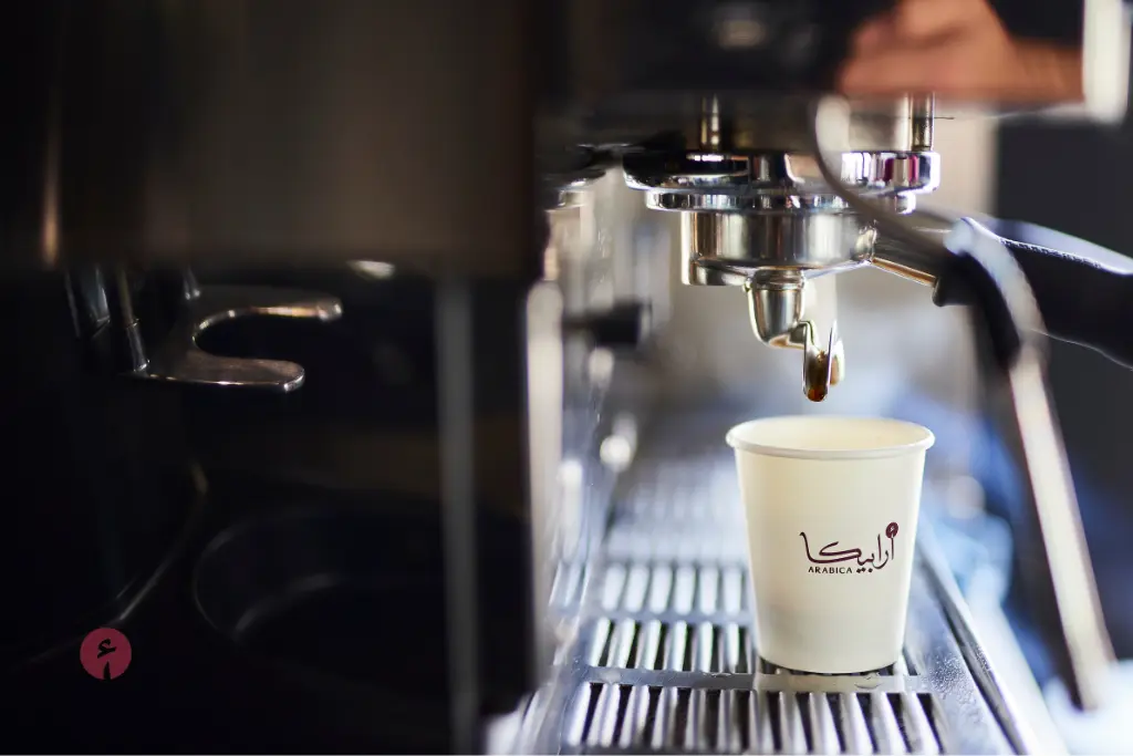 A barista at Arabica Café preparing a specialty coffee drink for 2025 trends.